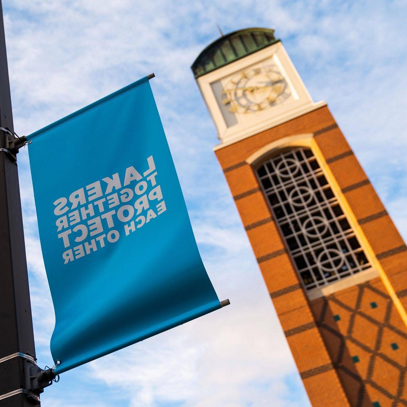 A Cook Carillon Tower with a banner saying 'Lakers Together Protecting Each Other'